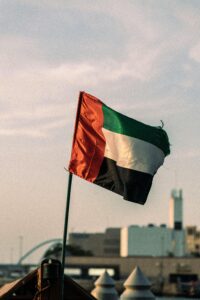 United Arab Emirates flag fluttering in a Dubai urban setting, captured during the day.